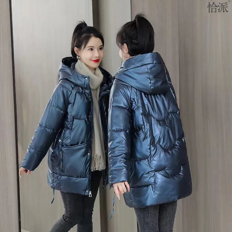 Green loose-fit hooded winter jacket for women on a hanger, showing long sleeves.