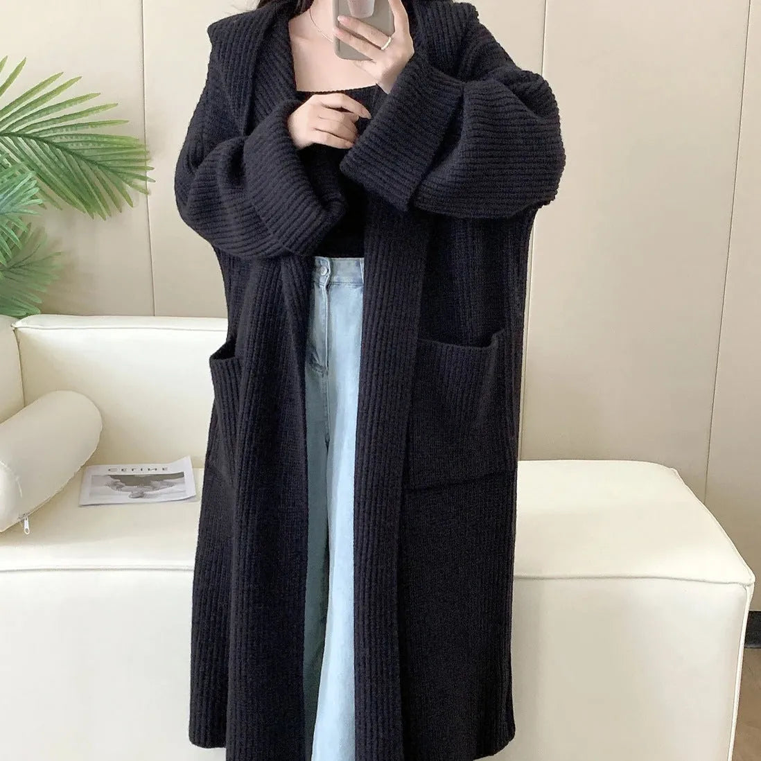 Loose grey hooded cardigan coat with raglan sleeves shown on a hanger.
