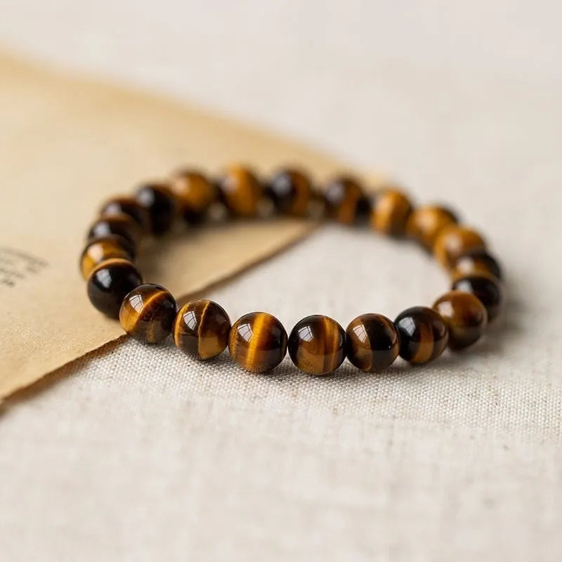 Single tigereye bead ethnic Buddha bracelet on wrist, showing simple rosary style.