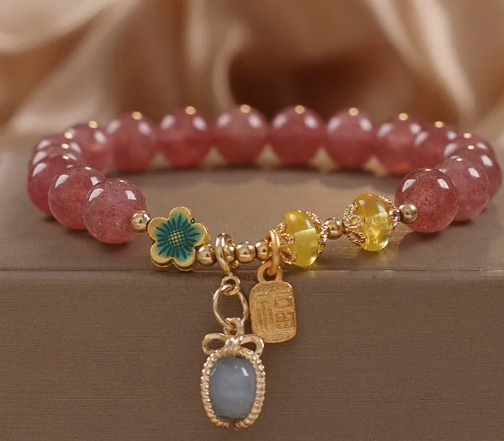 Red bracelet with strawberry quartz beads, alloy metal spacers, and rhinestone decorative details.