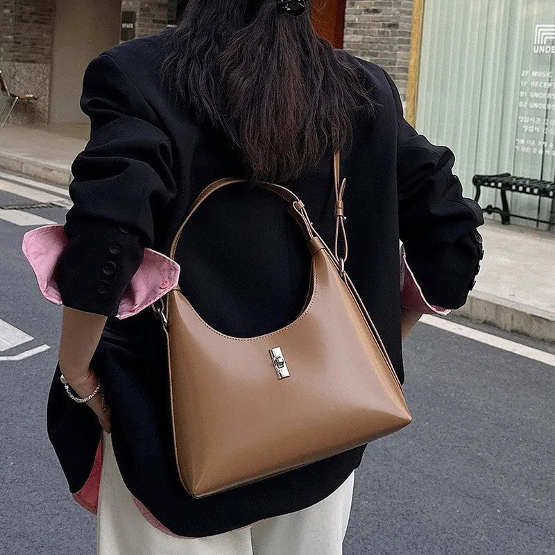 Soft genuine leather dumpling-shaped crossbody bag in apricot colour with visible stitching.