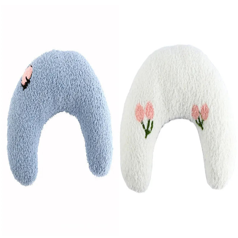 Plush white U-shaped pet pillow with raised rim for a cat or small dog to sleep curled up.