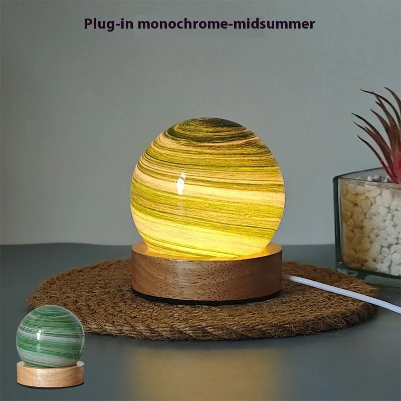Planet model night light with USB cable and base, showing three colour lighting options.