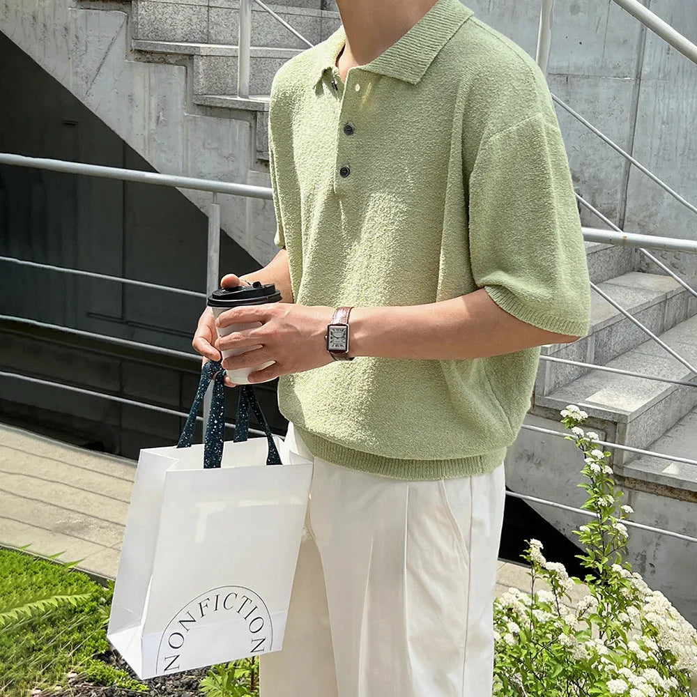 Man wearing a caramel coloured loose fit knitted polo shirt with short sleeves and an asymmetric design.