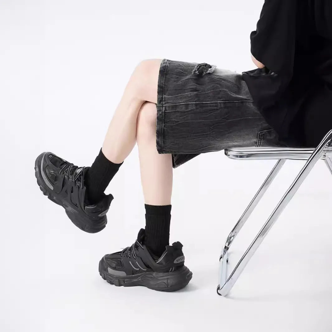 Men's loose fit distressed denim shorts in black vintage style with ripped detailing