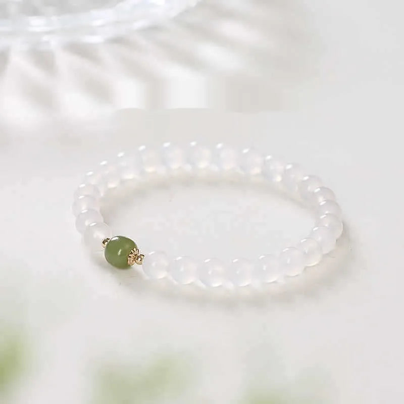 Handmade white agate and crystal bracelet with cinnabar inlay and text charm.