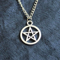 Vintage pentagram necklace on alloy adjustable chain, bronze finish, lying flat on grey surface