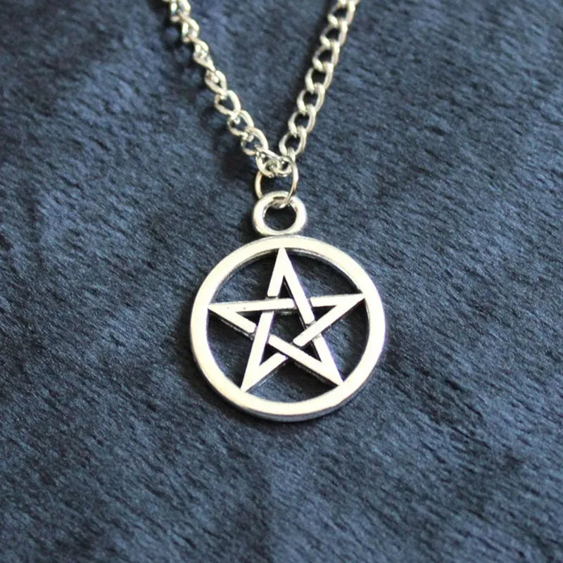 Vintage pentagram necklace on alloy adjustable chain, bronze finish, lying flat on grey surface