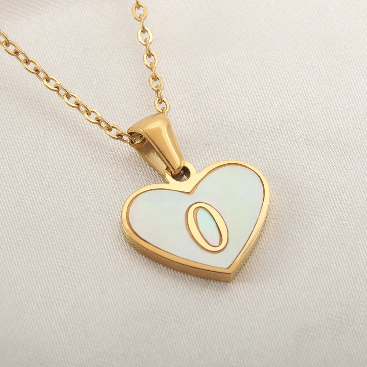 Gold plated chain necklace with a white shell heart-shaped pendant personalised with a single letter initial.
