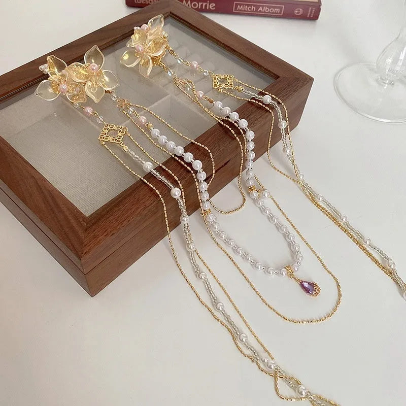 Gold grip acrylic hairpin with white pearl, clear diamond flower, and long beaded tassel decoration.