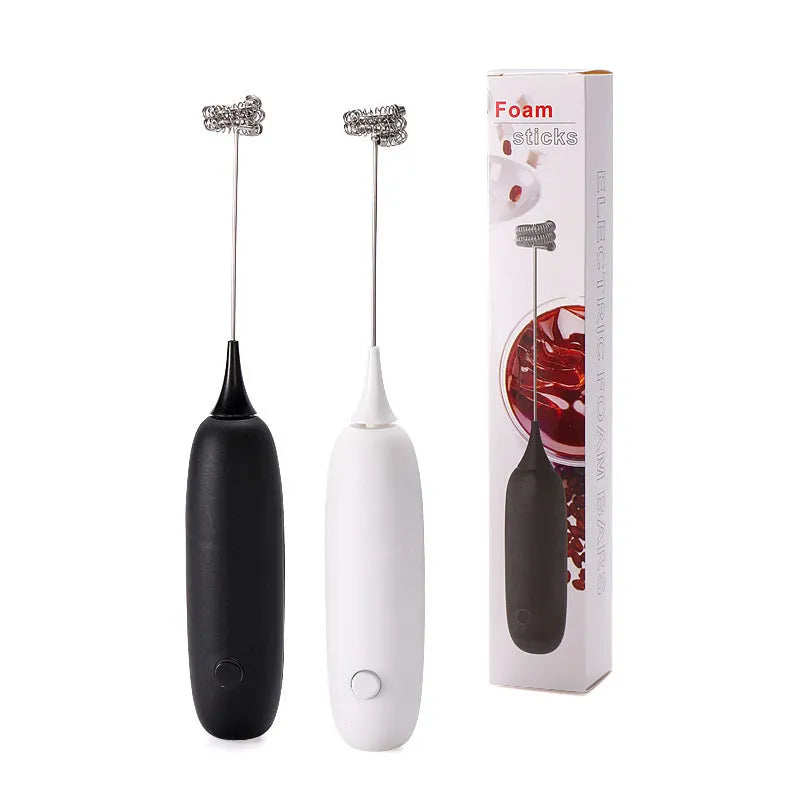 Black and white handheld electric milk frother and blender on a kitchen counter.