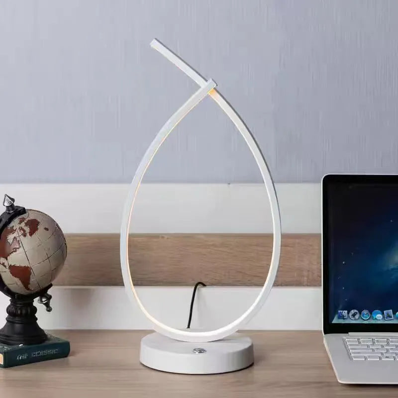 Black water drop shaped USB table lamp with touch control on wooden bedside table