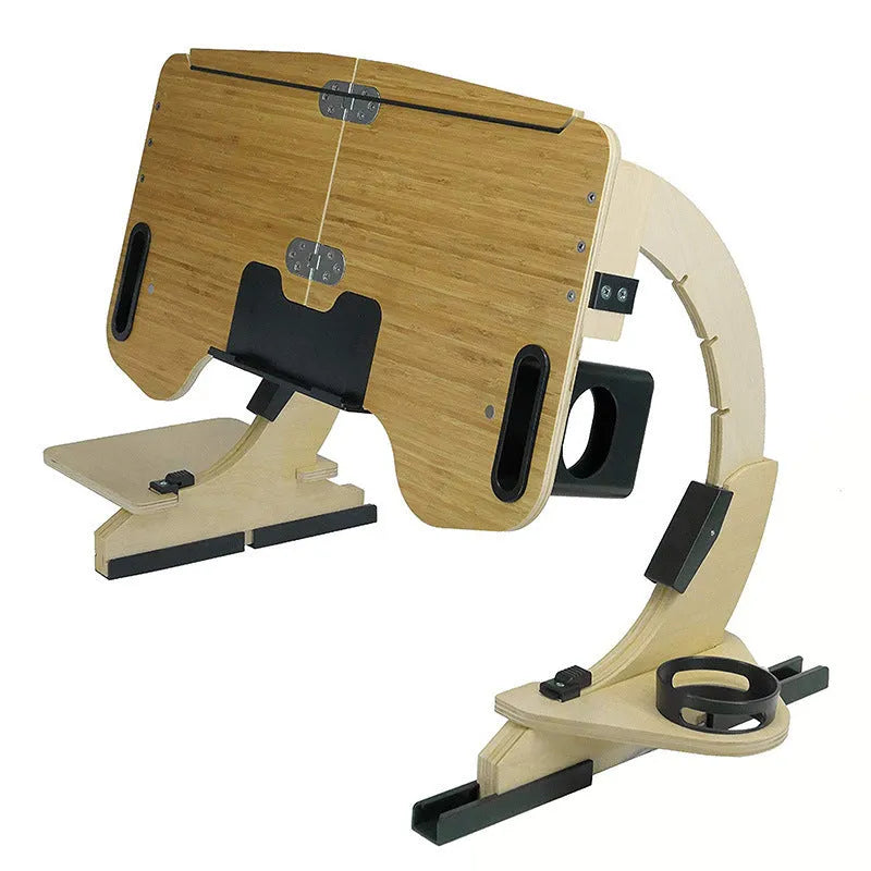 Wooden folding computer desk on a bed showing adjustable angle and laptop.