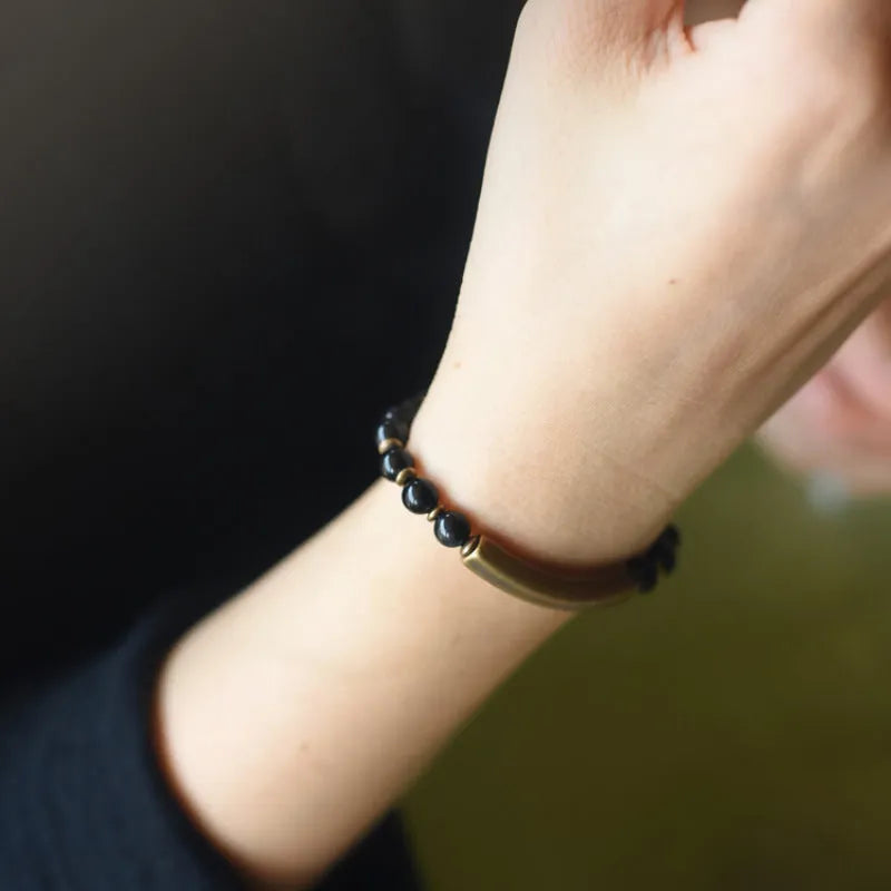 Layered ethnic bracelet with natural stones and brass components on a wrist