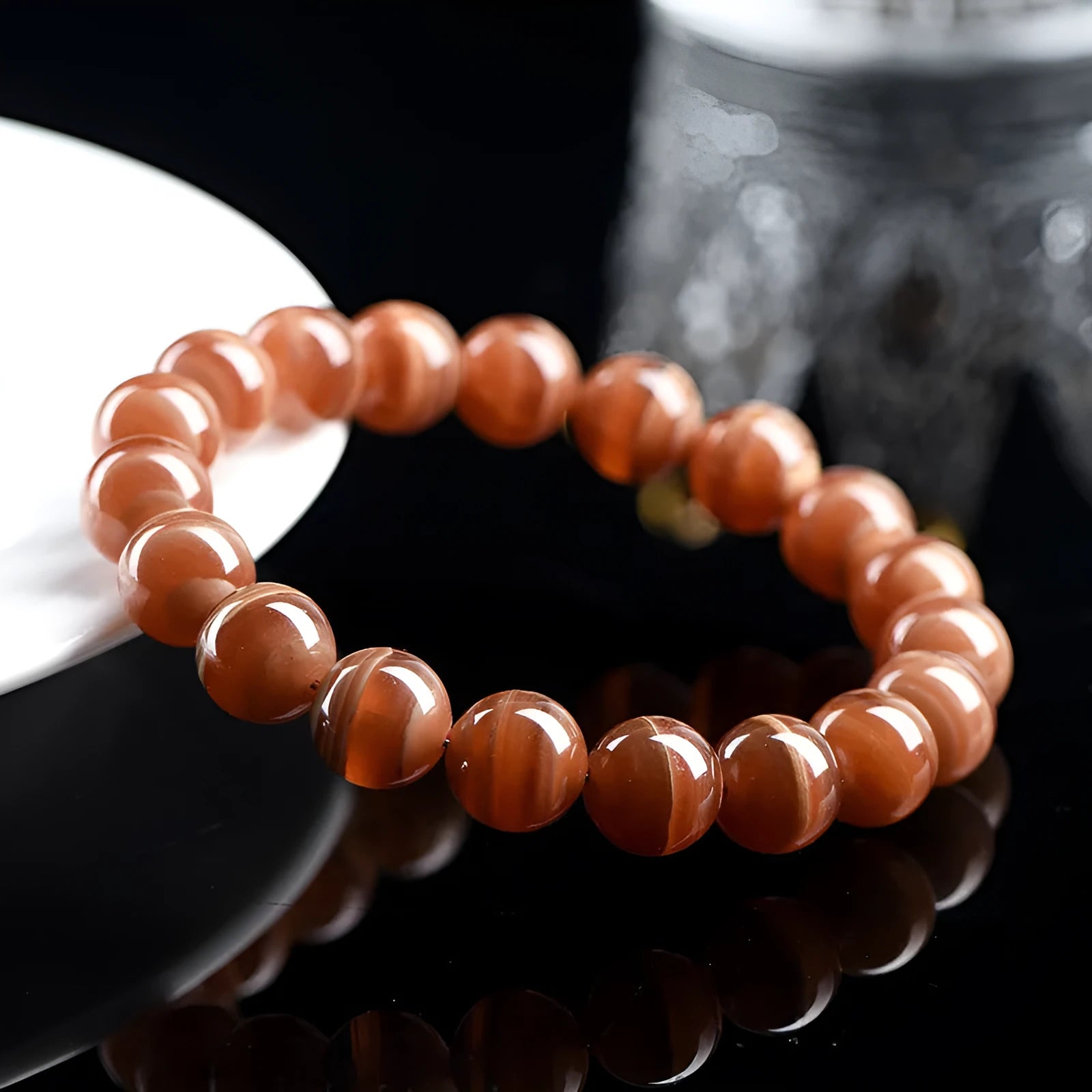 Natural old mine rhodochrosite round bead bracelet with ruyi detail, shown in 6mm and 8mm size options.
