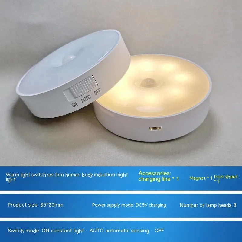 Small circular white motion sensing LED night light with USB charging cable and adhesive tape.