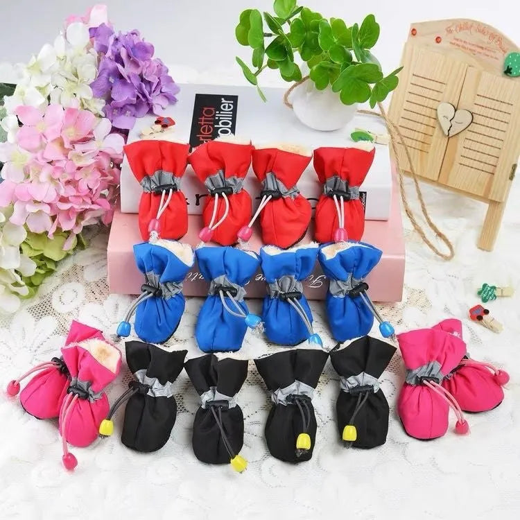 Set of four soft-soled cloth dog shoes for pets in assorted colours including red, blue, and black.