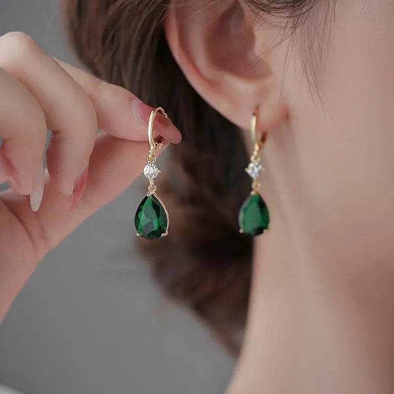 A pair of green geometric teardrop alloy earrings on a white background.