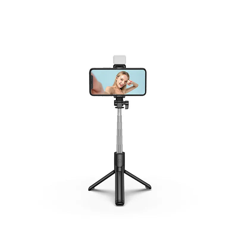 Black Bluetooth selfie stick extended from its integrated mini tripod base, holding a smartphone.