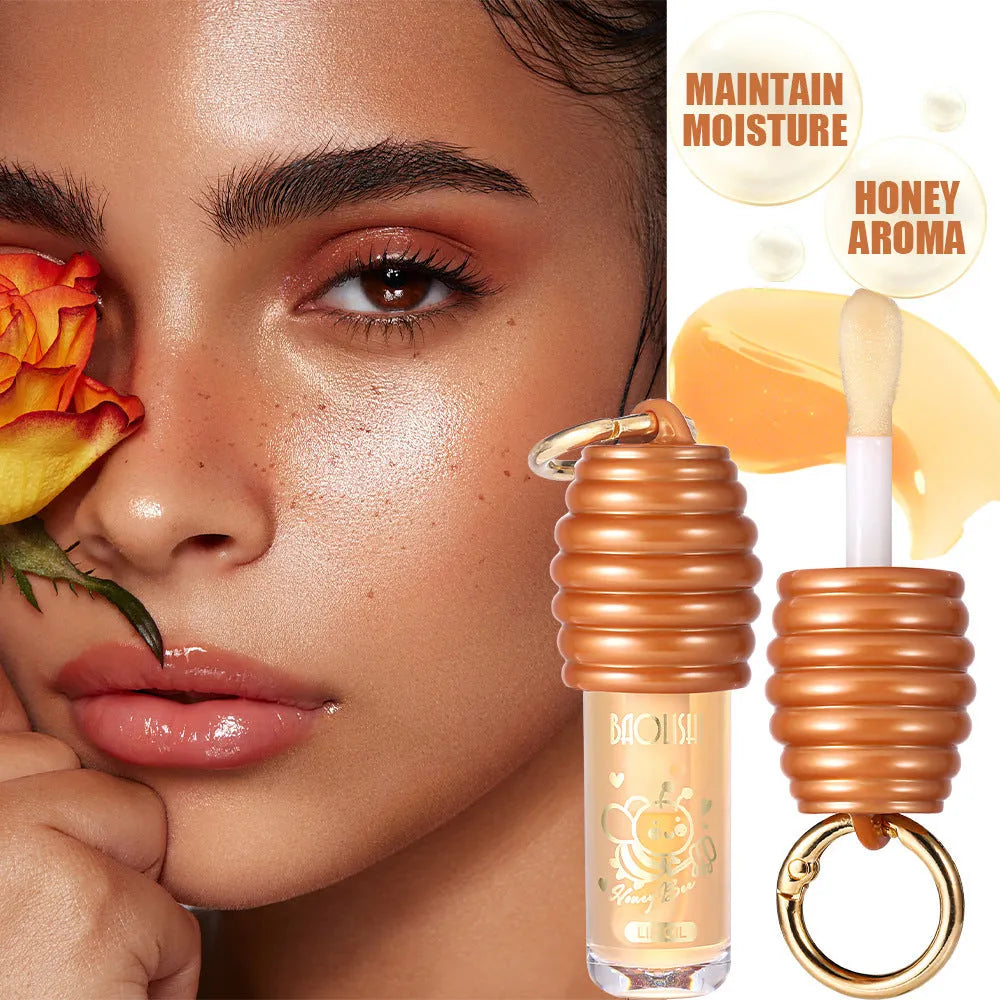 Honey lip gloss on a silver keychain clip against a neutral background.