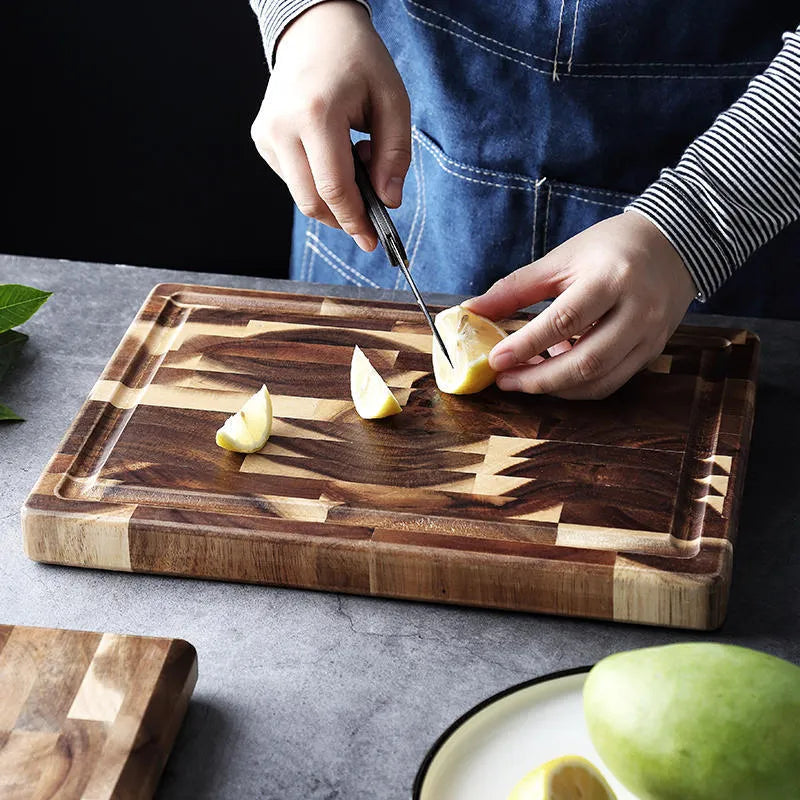 Brown solid wood chopping board with parquet pattern, shown on a kitchen countertop.