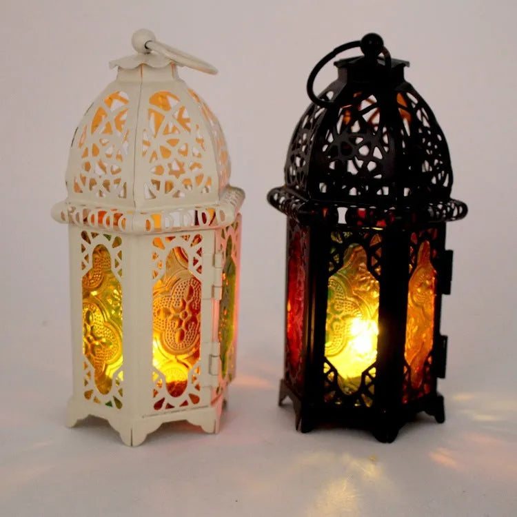 Handmade wrought iron hanging candle holder in black, 16cm tall and 7cm diameter, with a lit candle