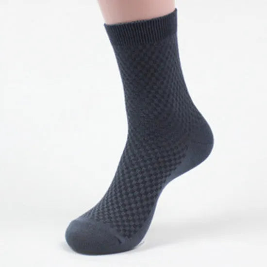 Men's bamboo fibre ankle socks in black with a small square pattern, laid flat.