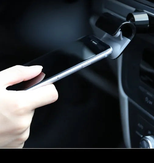 Black universal car phone holder with 360-degree rotation on a car dashboard.