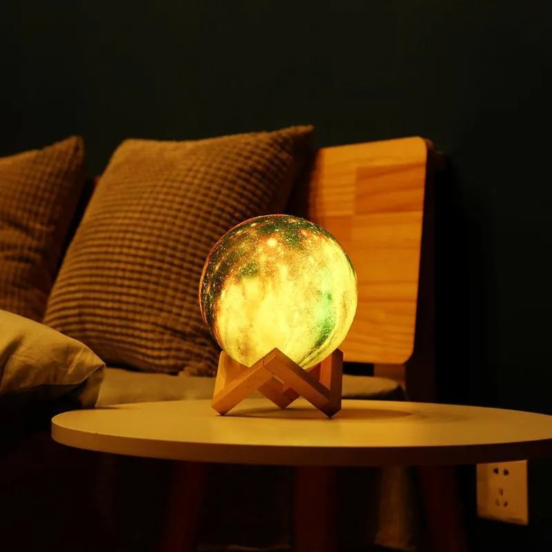 3D-printed white lunar sphere LED night light on a dark surface, showing detailed crater texture.