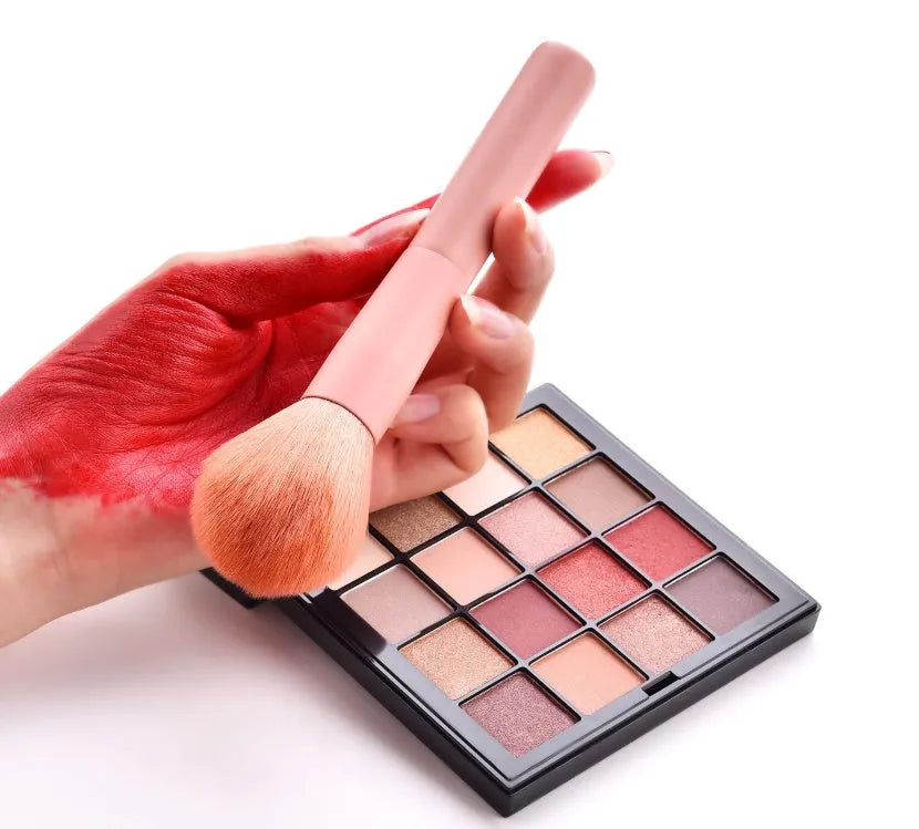 10-piece cosmetic brush set with pink wooden handles and nylon bristles arranged with makeup