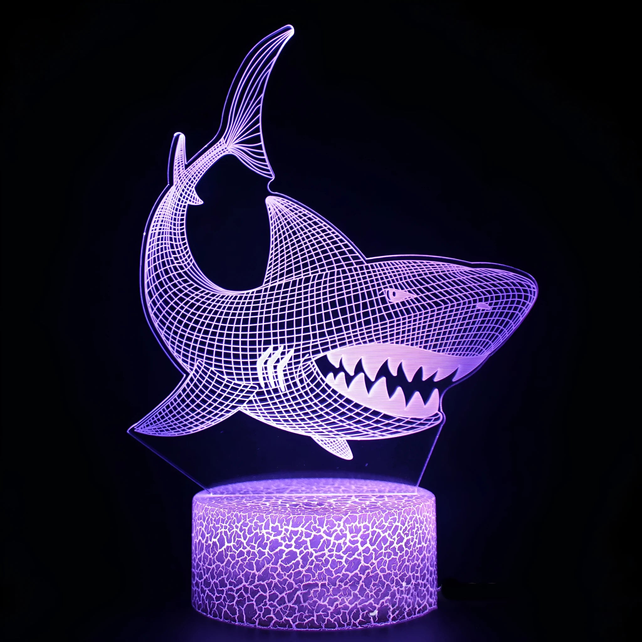 3D shark-shaped LED night light with colourful illumination on a bedside table