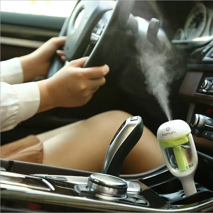 Compact blue car humidifier with rotating nozzle in vehicle cup holder