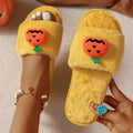 Yellow cartoon pumpkin plush slippers with open toe and anti-slip sole on a white background.