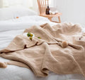 Nordic fringed acrylic blanket measuring 130×170cm in neutral colours