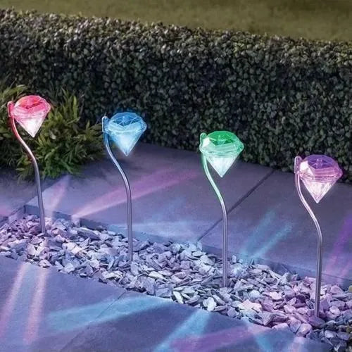 White solar-powered diamond-shaped garden spotlight with adjustable head on a stake.
