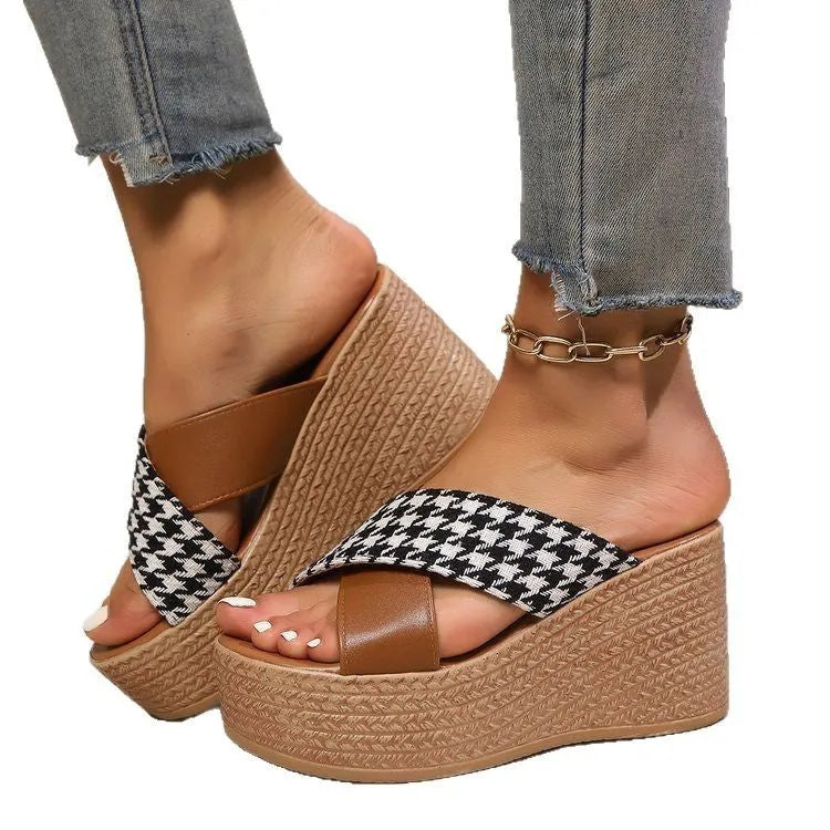 Leopard print plaid wedge sandals in brown and black with a rubber sole, shown in a casual setting.