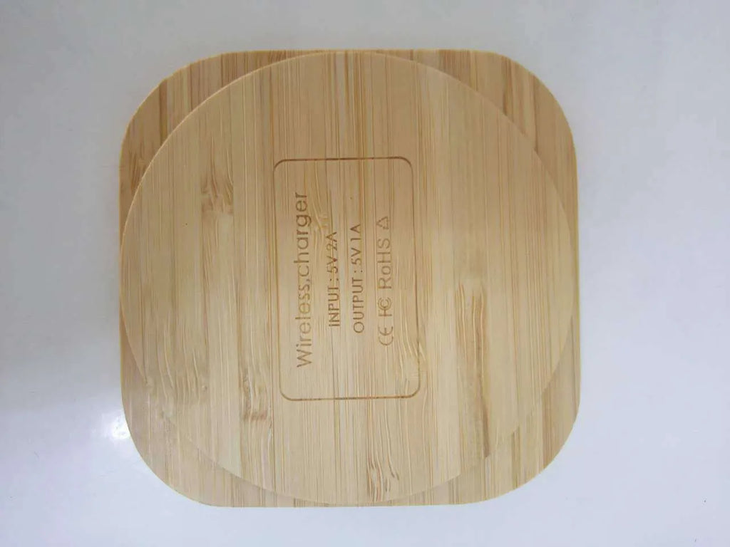 Square brown wooden bamboo 5W wireless charging pad for smartphones on a table.
