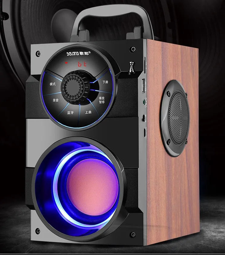 Black portable mini home audio system with subwoofer, satellite speakers, and USB charging cable on a desk.
