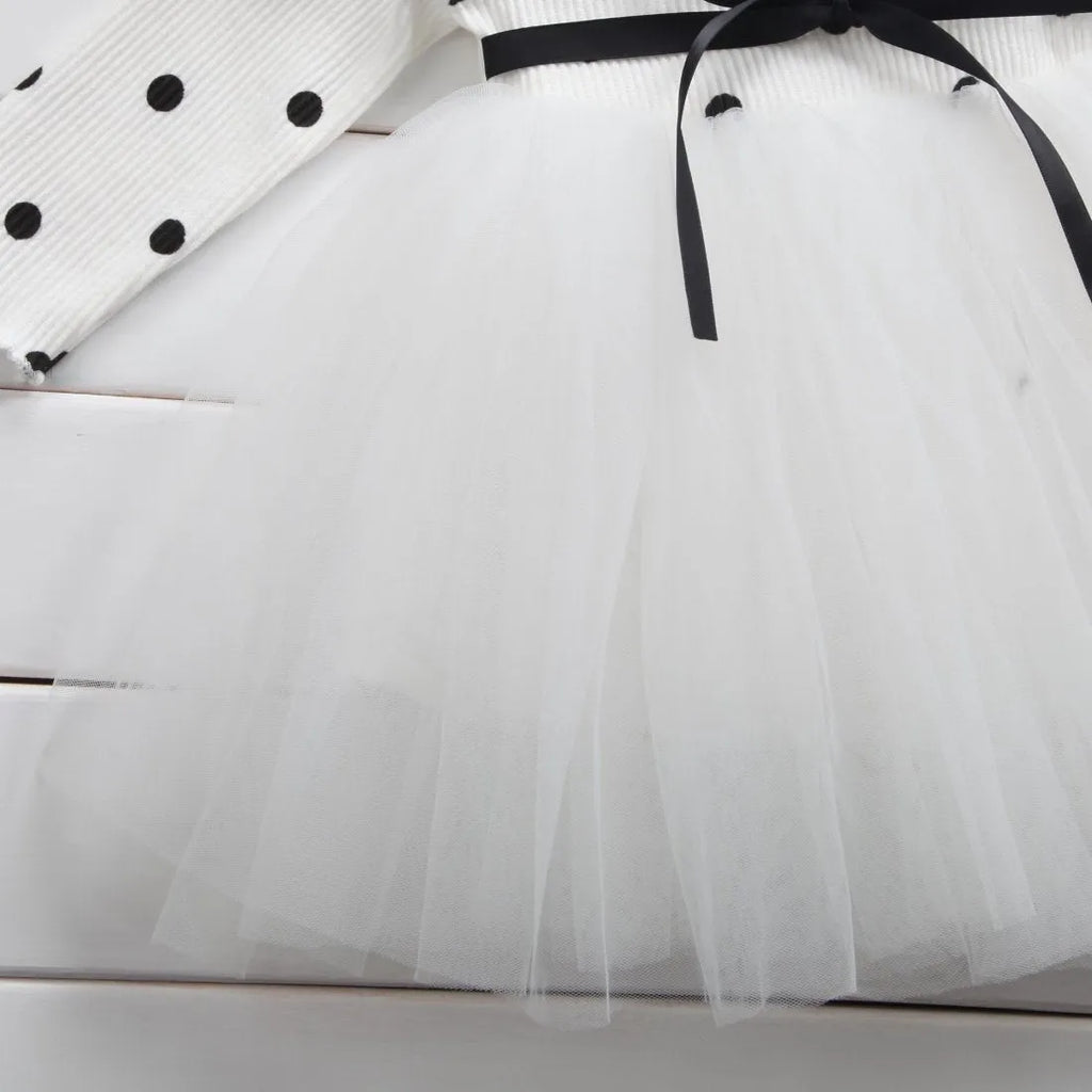 Baby girl wearing long sleeve lace tutu dress in pink, suitable for first birthday or christening events