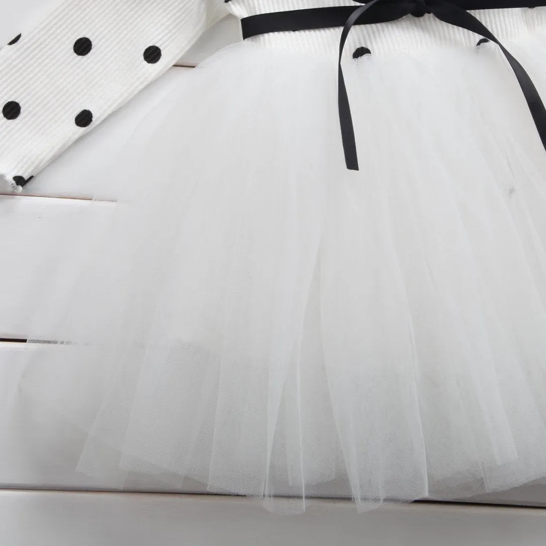 Baby girl wearing long sleeve lace tutu dress in pink, suitable for first birthday or christening events
