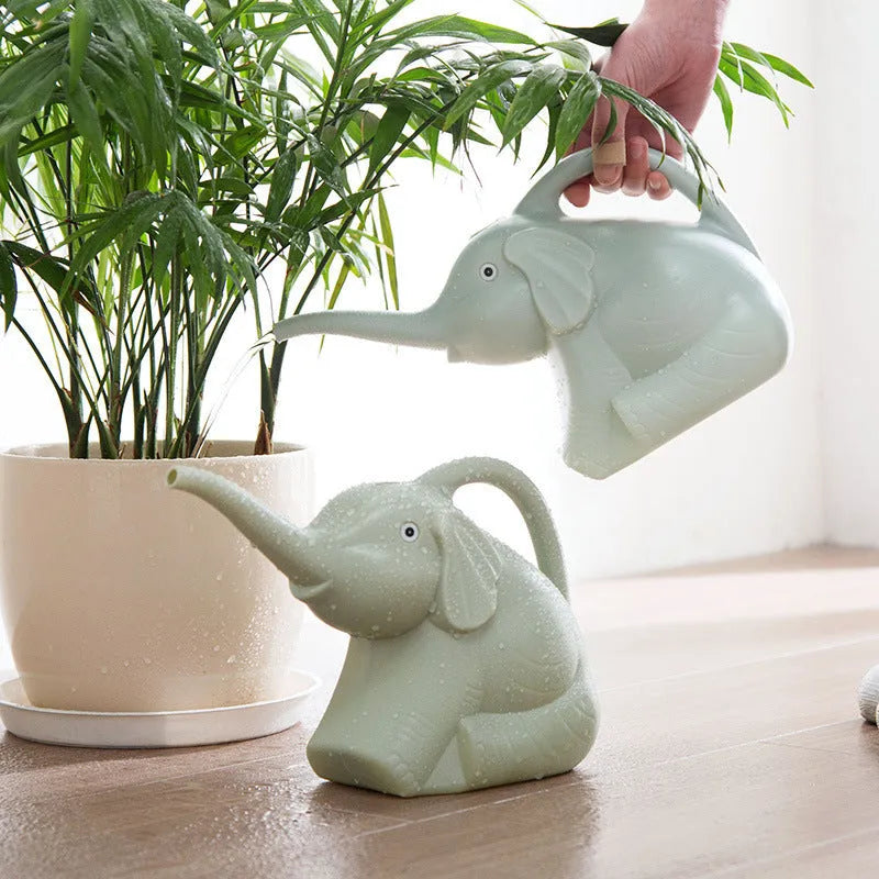 Pink children's watering can shaped like a sitting elephant with a long spout and baby-bottle handle.