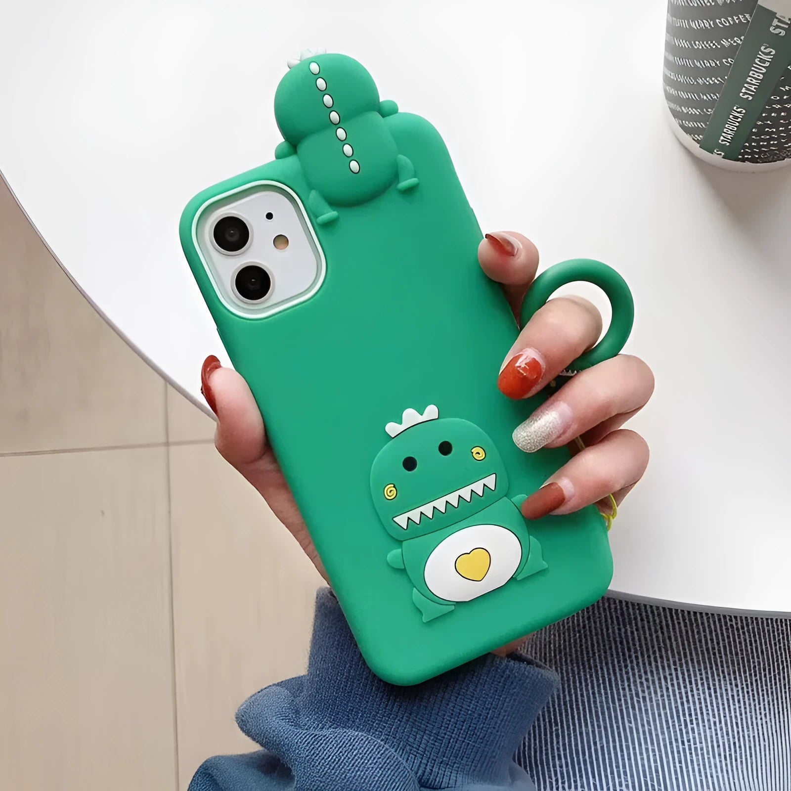 Green silicone iPhone case with a cartoon animal design on the back.