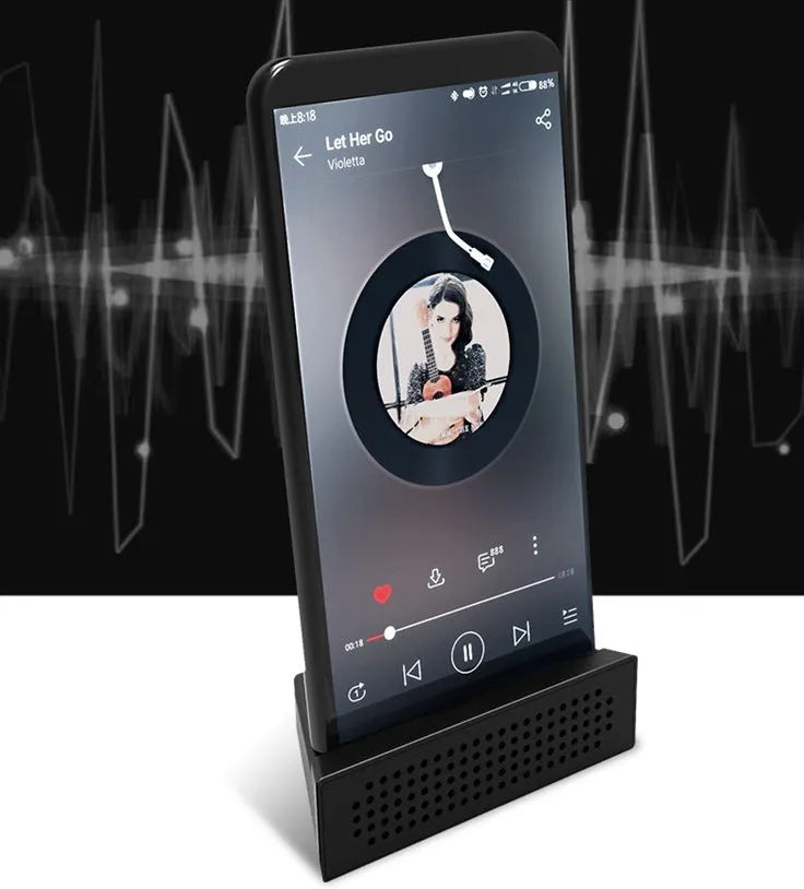 Mini black mobile phone amplifier bracket holding iPhone on desktop surface