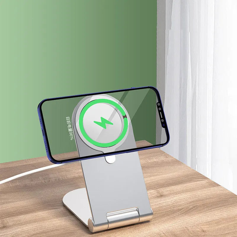 Silver vertical aluminium alloy magnetic phone bracket for iPhone 12 on a table.