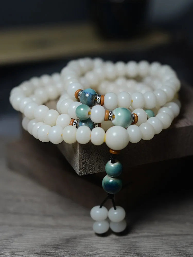 White Jade Bodhi Root Oblate Bead Bracelet with 108 flat round beads on a wrist.