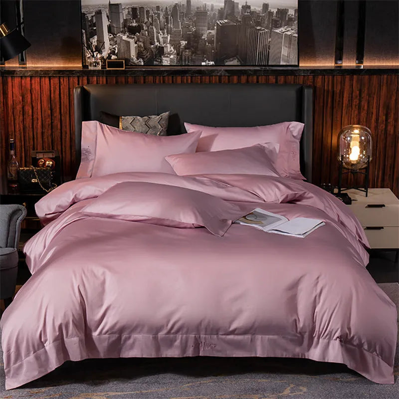 Four-piece cotton satin quilted bedding set with duvet cover, sheet, and pillowcases in a bedroom setting