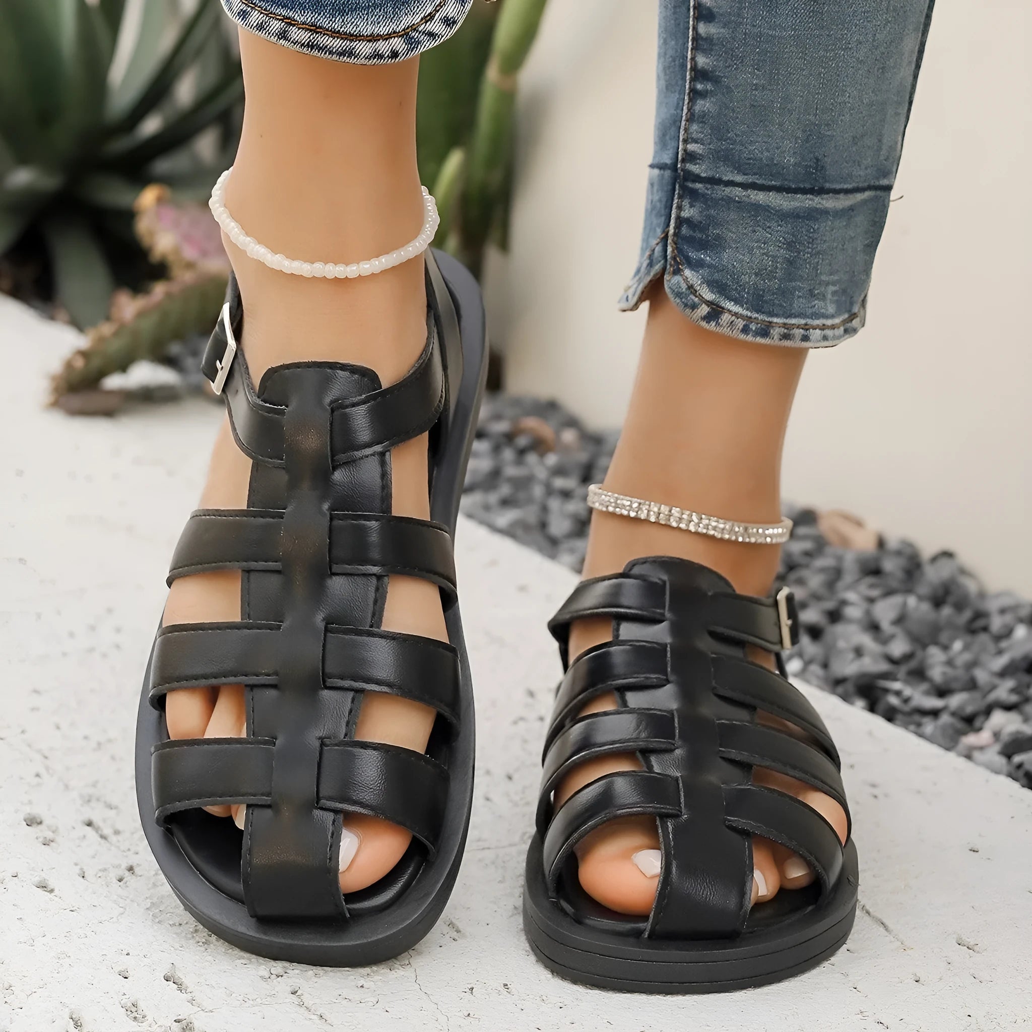 Flat Roman style women's sandals with PU upper and buckle fastening in black