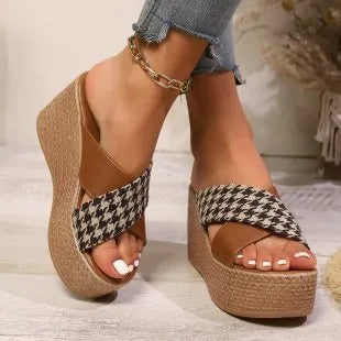 Leopard print plaid wedge sandals in brown and black with a rubber sole, shown in a casual setting.