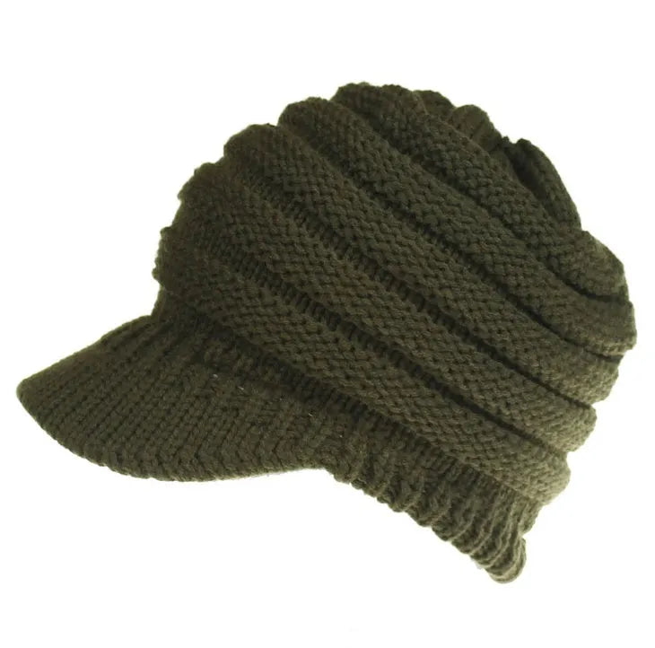 Woman wearing a thick knitted beanie with her ponytail pulled through the hole in the crown.