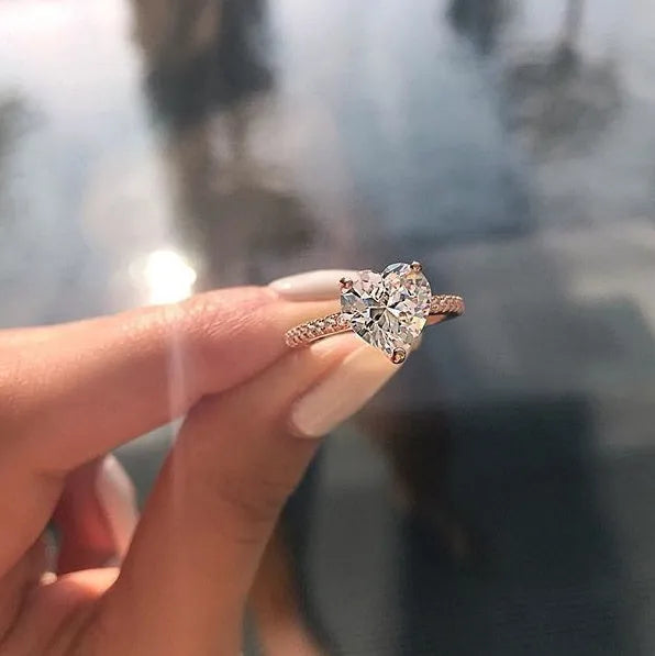 White gold alloy heart-shaped ring with AAA zircon stone on a light background